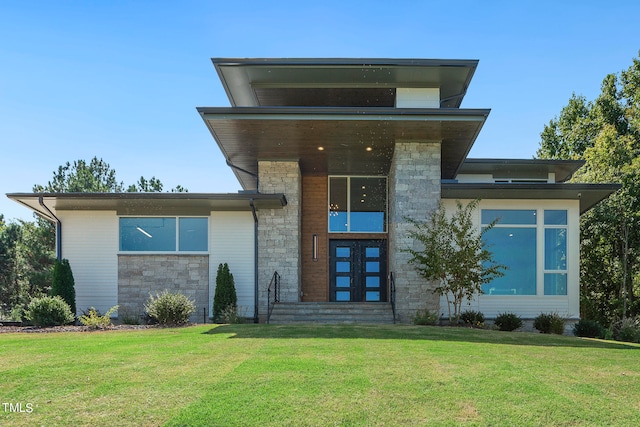 modern home with stone siding and a front lawn