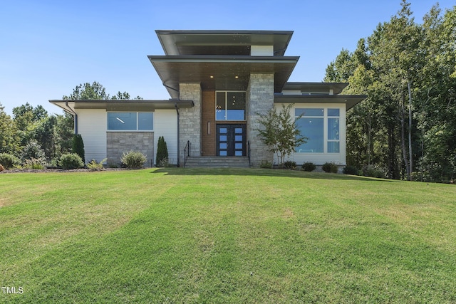 view of front of house with a front yard and stone siding