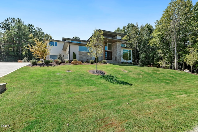 view of front facade featuring stone siding and a front lawn