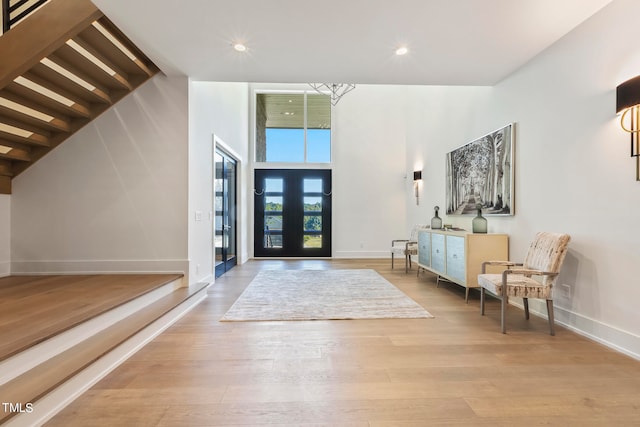 entryway with french doors, recessed lighting, a high ceiling, wood finished floors, and baseboards