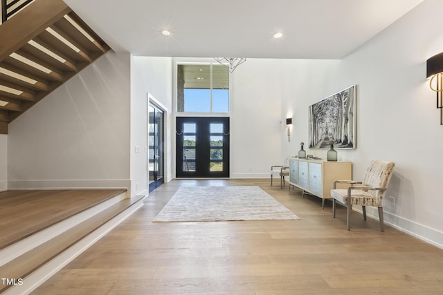 entrance foyer with recessed lighting, wood finished floors, baseboards, and a towering ceiling