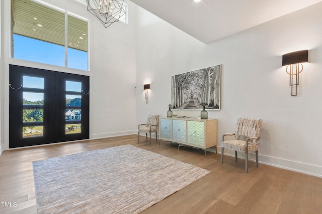 entryway with a chandelier, a high ceiling, wood finished floors, and baseboards