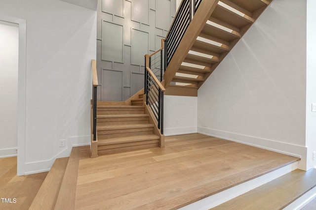 stairway featuring baseboards and wood finished floors