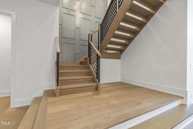 stairway featuring wood finished floors and baseboards