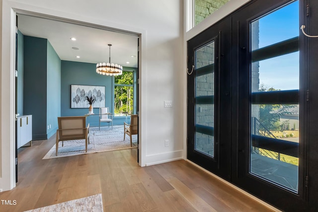 doorway to outside with a chandelier, french doors, and wood finished floors