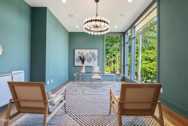 sitting room with baseboards, radiator, wood finished floors, an inviting chandelier, and recessed lighting