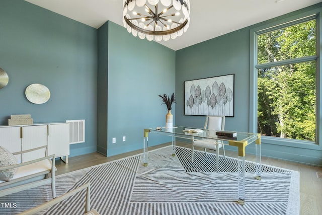 home office featuring an inviting chandelier, a healthy amount of sunlight, visible vents, and baseboards