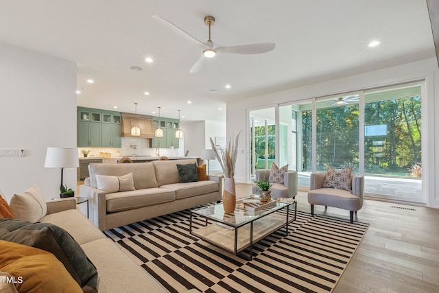 living room featuring light wood-type flooring, a wealth of natural light, and recessed lighting