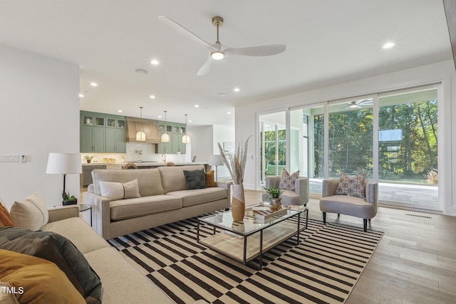 living room with a wealth of natural light, recessed lighting, light wood-type flooring, and a ceiling fan