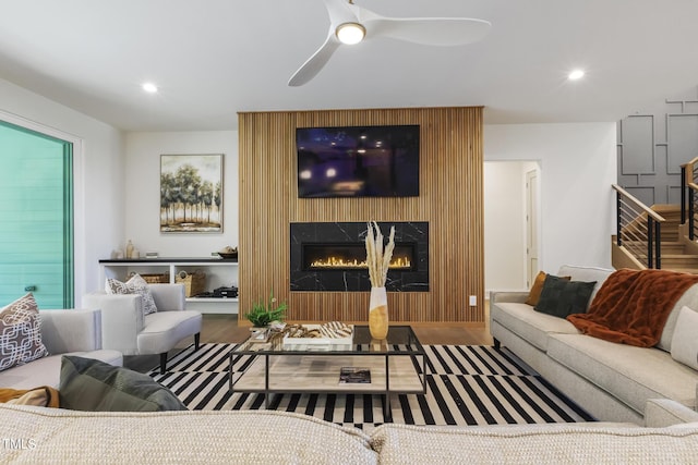 living area with recessed lighting, a ceiling fan, and a premium fireplace