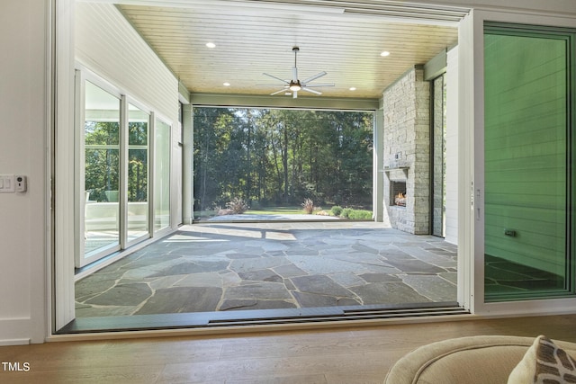 entryway with wooden ceiling, stone finish floor, recessed lighting, and an outdoor stone fireplace