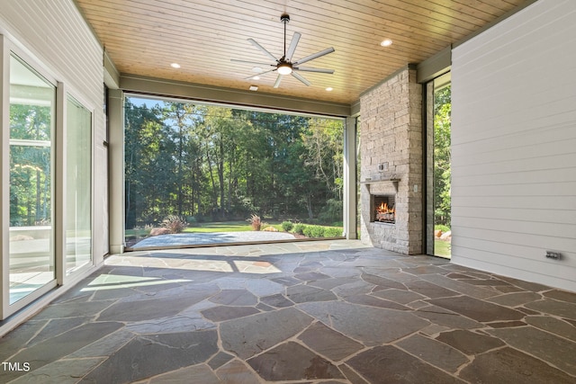 view of patio / terrace with an outdoor stone fireplace and a ceiling fan