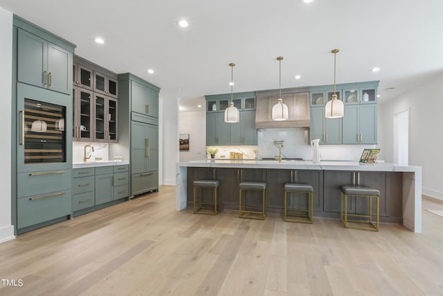 kitchen featuring light wood-type flooring, paneled built in fridge, backsplash, and light countertops