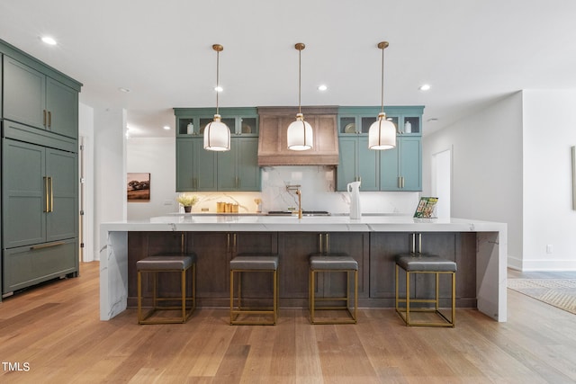 kitchen featuring built in fridge, light countertops, light wood-style floors, and backsplash