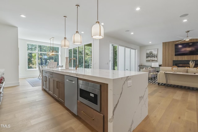 kitchen with open floor plan, light wood-type flooring, recessed lighting, appliances with stainless steel finishes, and a sink