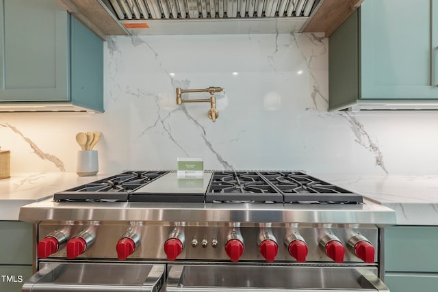 kitchen featuring light stone counters, double oven range, and decorative backsplash