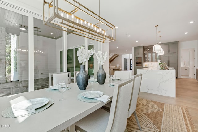 dining area featuring a ceiling fan, recessed lighting, stairway, and light wood finished floors