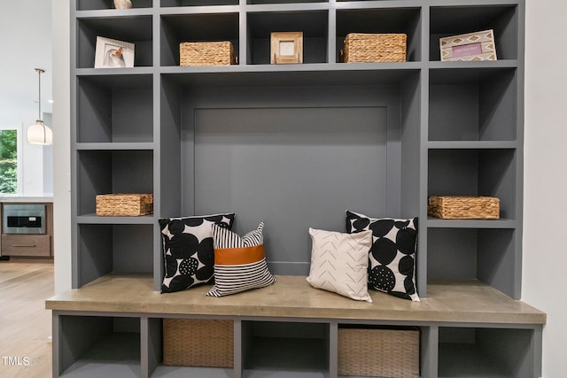 mudroom with built in shelves and wood finished floors