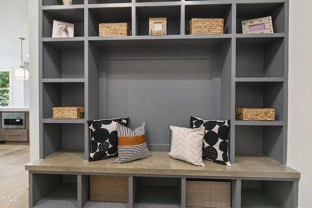 mudroom featuring built in features and wood finished floors