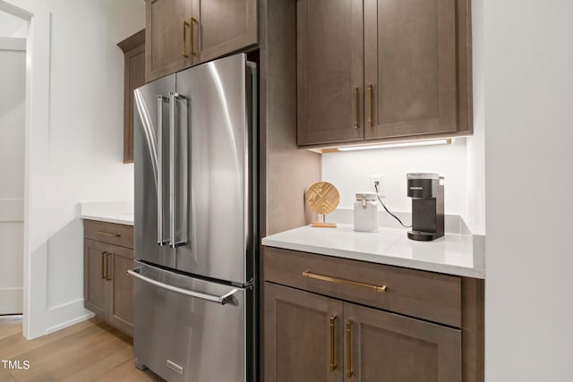 kitchen featuring light countertops, light wood finished floors, and high end refrigerator