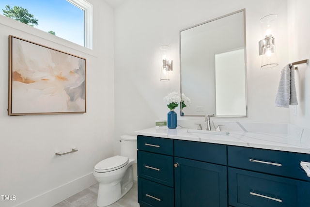 bathroom with toilet, baseboards, and vanity