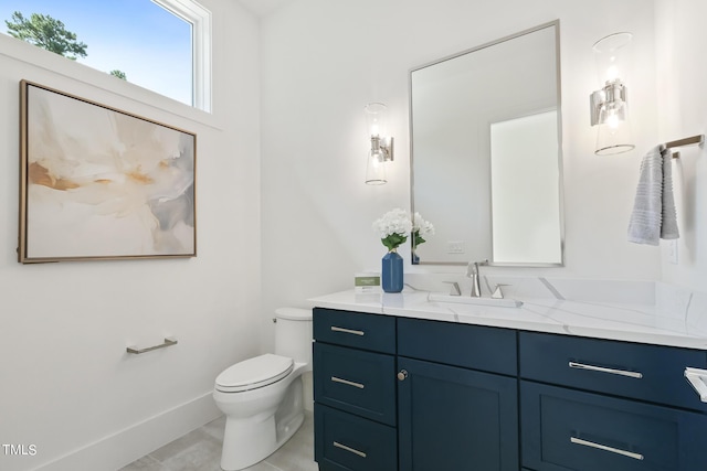 bathroom featuring baseboards, toilet, and vanity