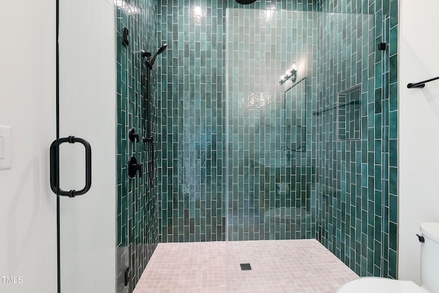 bathroom featuring toilet and a shower stall