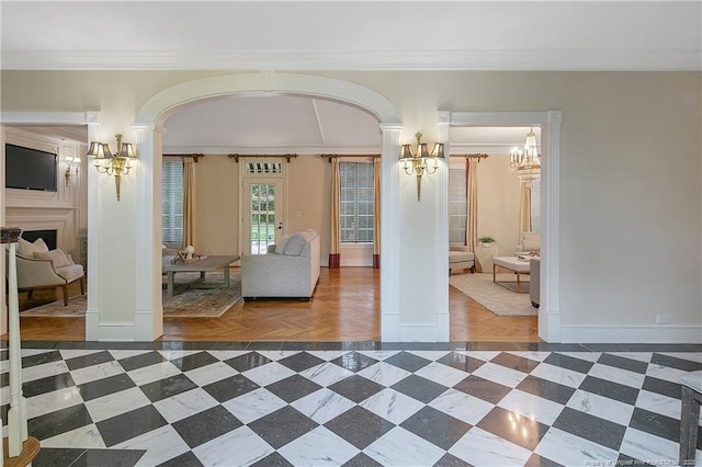 interior space with decorative columns, a notable chandelier, and ornamental molding