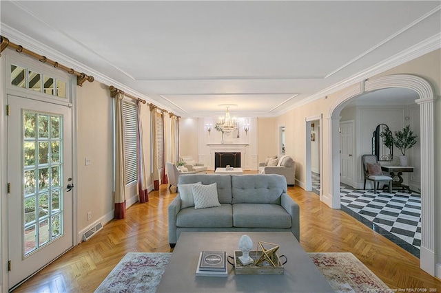 living room featuring light parquet floors, an inviting chandelier, and crown molding