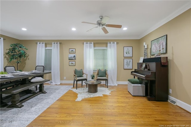 interior space with ceiling fan, crown molding, and light wood-type flooring