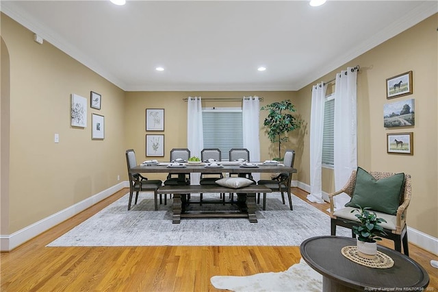 dining space with ornamental molding and light wood-type flooring