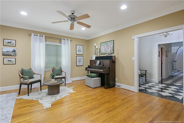 sitting room featuring hardwood / wood-style floors, ceiling fan, and ornamental molding