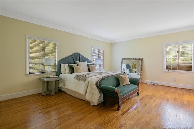 bedroom featuring crown molding and light hardwood / wood-style flooring