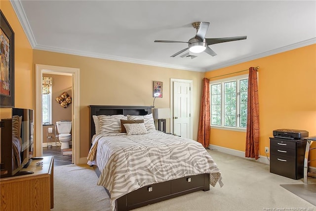 carpeted bedroom with ceiling fan, ornamental molding, and ensuite bathroom