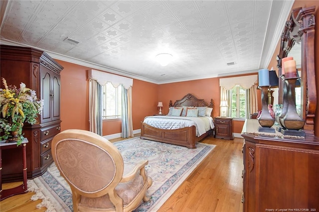 bedroom featuring ornamental molding and light hardwood / wood-style floors