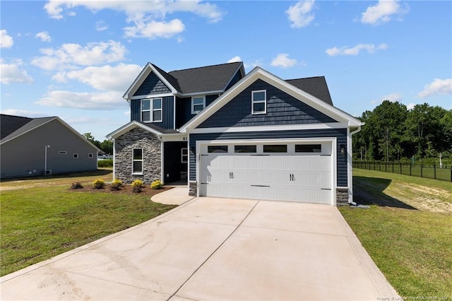 craftsman inspired home featuring driveway, a front lawn, stone siding, and fence