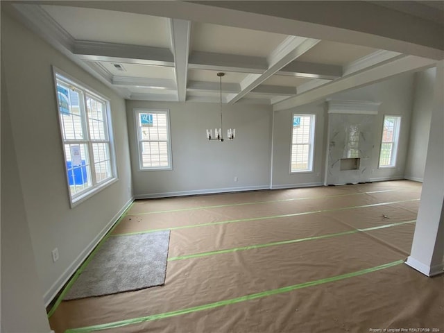 empty room with beamed ceiling, coffered ceiling, and a notable chandelier