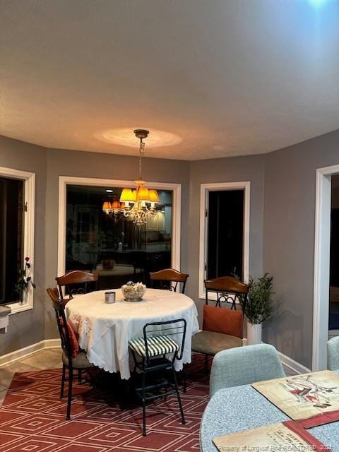dining space with an inviting chandelier and baseboards