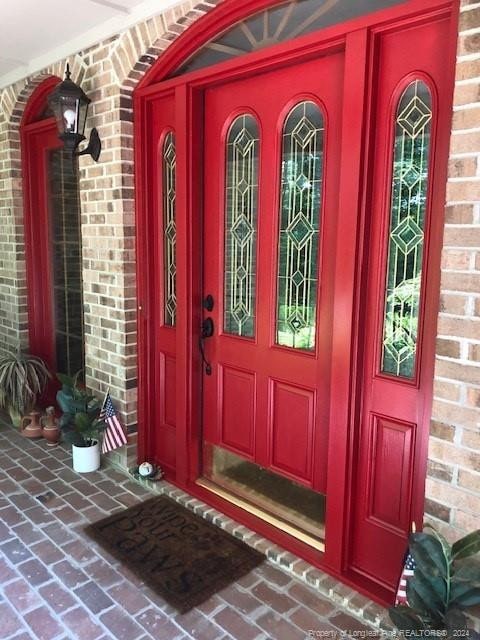 view of exterior entry with brick siding