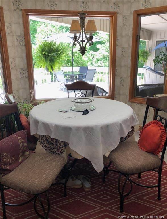 dining space featuring plenty of natural light and a notable chandelier