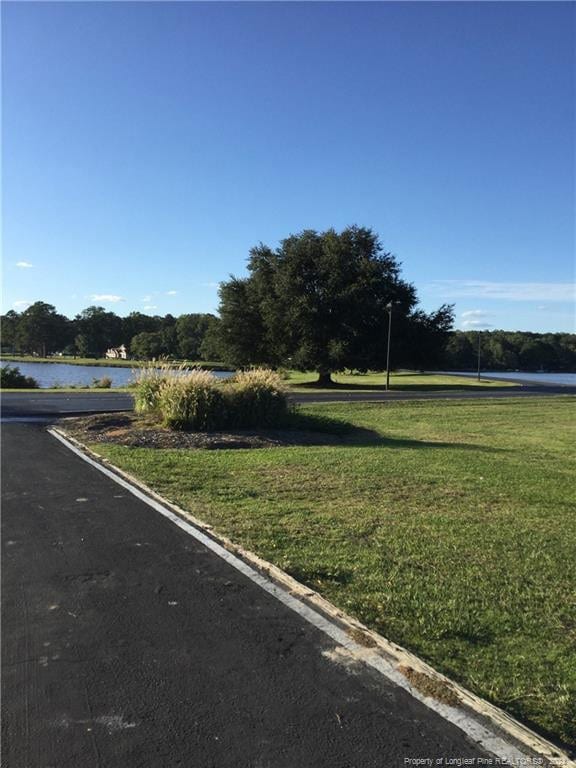 view of road featuring a water view and curbs