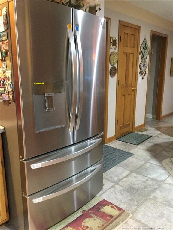 details featuring baseboards, light countertops, and stainless steel refrigerator with ice dispenser