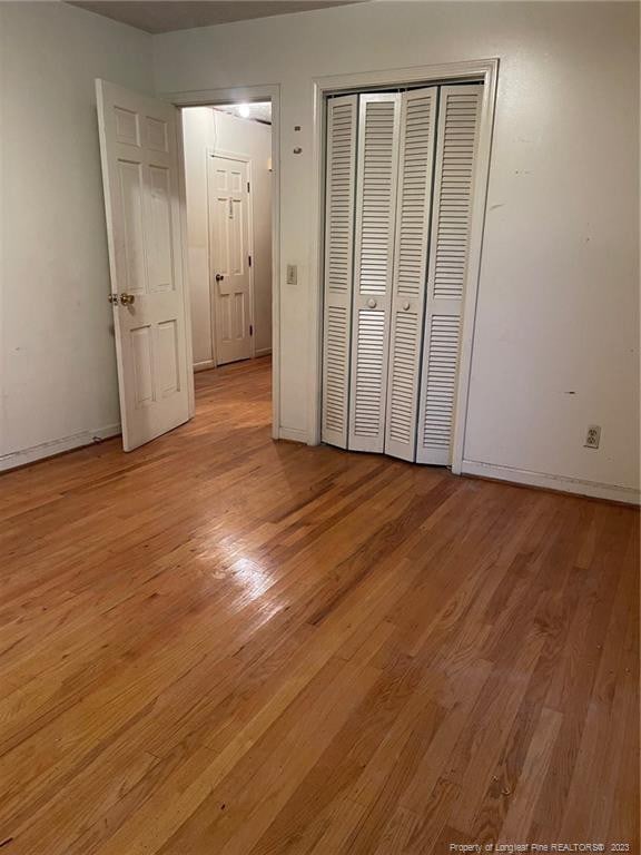 unfurnished bedroom featuring light hardwood / wood-style floors and a closet