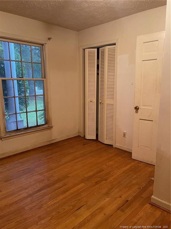 unfurnished bedroom featuring a textured ceiling and wood-type flooring