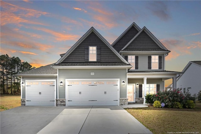 craftsman-style house with a lawn, a porch, and a garage