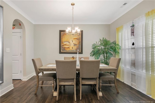 dining space featuring dark hardwood / wood-style flooring, a notable chandelier, and ornamental molding