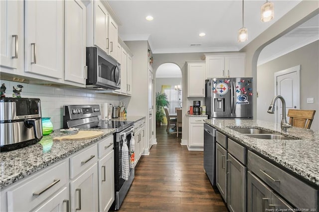 kitchen with hanging light fixtures, stainless steel appliances, white cabinetry, and dark hardwood / wood-style flooring