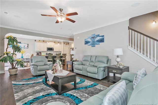 living room with ornamental molding, ceiling fan, and dark hardwood / wood-style flooring