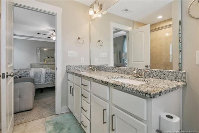 bathroom with vanity with extensive cabinet space, dual sinks, tile floors, and ceiling fan