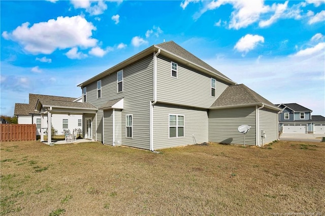 rear view of house with a lawn and a patio